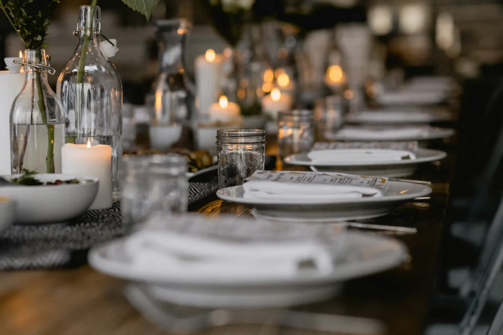 Fotografia de alto padrão que retrata a excelência em eventos corporativos e curadoria gastronômica. O ambiente minimalista e sofisticado, composto por tons de preto, grafite, dourado e marfim, transmite o rigor estético, a exclusividade e o acolhimento necessários para transformar reuniões e comemorações em experiências memoráveis e impecáveis de ponta a ponta.